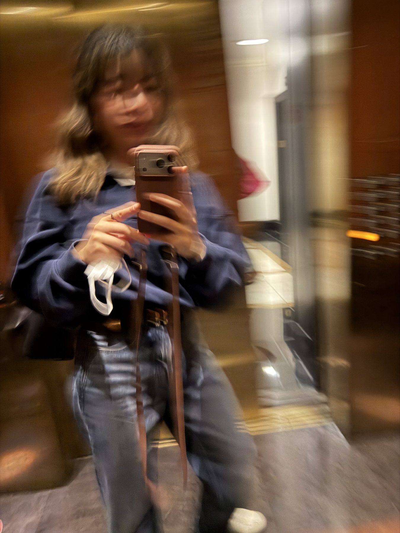 A motion-blurred mirror photograph of the author holding a phone, features indistinct.